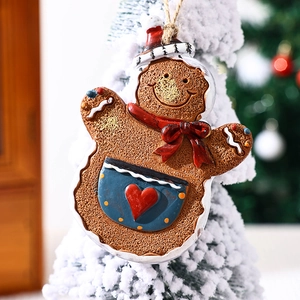 Macro detail of gingerbread man resin ornament with red bow on a Christmas tree