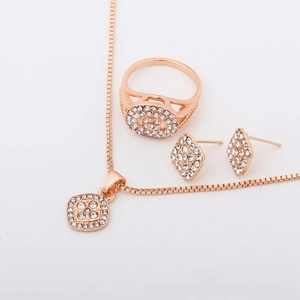 Detailed view of rose gold jewelry set with square pendant and pavé rhinestone ring