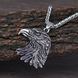 Vintage Viking style eagle head pendant necklace on textured wood background