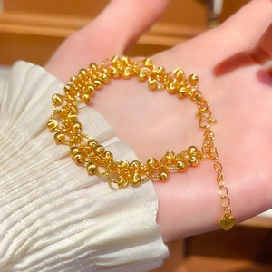 Detail of 24K gold plated bead bracelet featuring a heart pendant and S-hook clasp on wrist