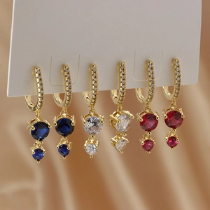 Elegant gold earrings set with colorful round zircon pendants in blue, white, and rose red