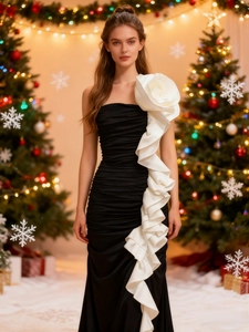 Elegant black mermaid evening dress with a large white flower on the shoulder