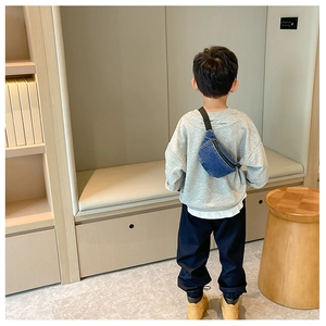 Kids casual blue denim waist bag worn as a crossbody chest bag by child model