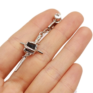 Close-up of silver cross belly clip with black square stone and white round gem