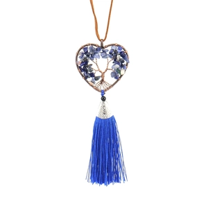 Detail of tree of life heart pendant with blue stones and long hanging silk tassel