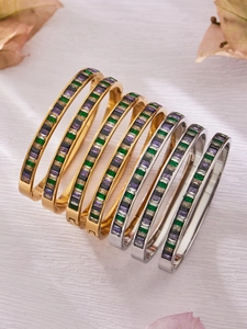 Detailed view of stacked gold and silver stainless steel bangles with baguette zircons
