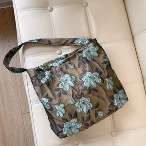 Dettaglio del tessuto jacquard floreale vintage verde scuro su una borsa a spalla