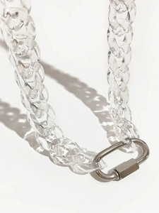 Macro shot of transparent acrylic chunky chain link with silver metal carabiner clasp