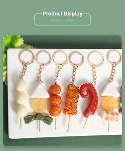 Dettaglio di portachiavi realistici in PVC con spiedini di carne su un piatto di ceramica