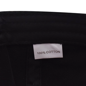 Primer plano de la etiqueta de lavado que indica 100% algodón en una gorra negra