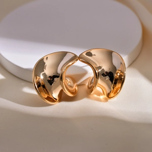 Details von eleganten goldenen Spiral-Ohrsteckern mit minimalistisch geschwungenem Design