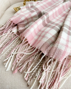 Close-up of pink and beige plaid cashmere scarf with soft fringes and knit texture