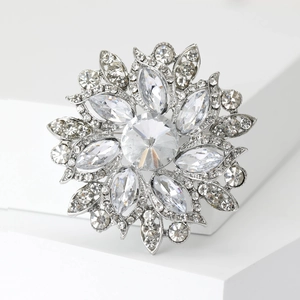 Detail of flower brooch with crystal petals on a minimal white background