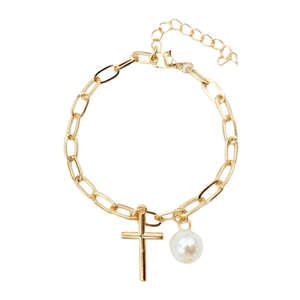 Detail of gold paperclip chain bracelet featuring cross charm and white pearl bead