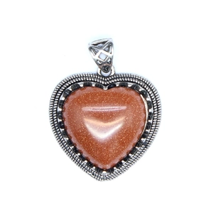 Macro shot of heart-shaped natural stone pendant with vintage beaded silver frame