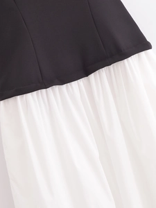 Detail of contrast stitching between black smooth fabric and white pleated skirt