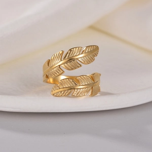Elegant gold feather open ring in stainless steel with detailed texture on white disc