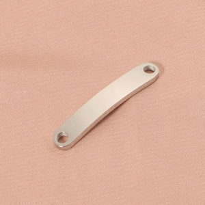 Close-up of a silver curved stainless steel bar connector with holes on pink fabric