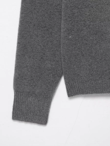 Macro shot of fine grey knit fabric showing detailed ribbed cuffs and hem textures