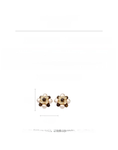 Detailed macro view of 18k gold plated flower stud earrings with tiger eye stone and pearls