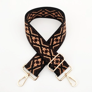 Detail view of adjustable jacquard strap with gold hardware and geometric pattern