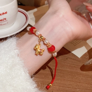 Détail du bracelet en corde rouge tressée avec perles de cristal et pendentif poney