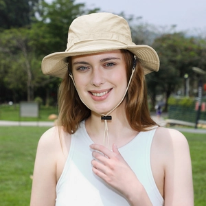 Khaki outdoor sun hat with windproof drawstring worn by a model in a natural park setting