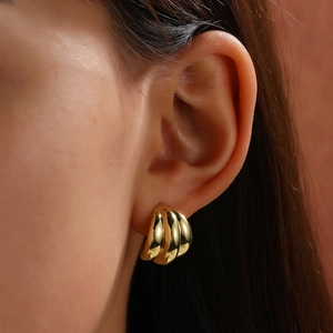 Minimalist geometric C-shaped hoop earrings in 18k gold plating shown on model