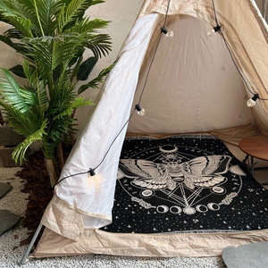 Detail of bohemian moth woven blanket with moon phases inside a cozy camping tent
