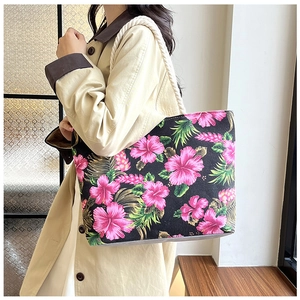 Detail of floral canvas tote bag with pink hibiscus print and white rope shoulder strap