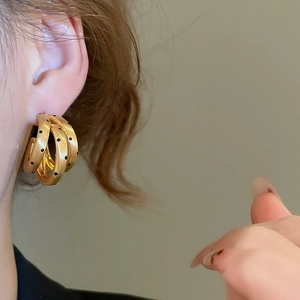 Dettaglio di orecchini a cerchio a C a tre strati placcati oro 18k con pois neri