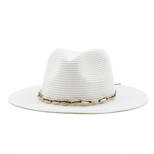 Detail of white woven straw cowboy hat with a brown shell and gold bead band decoration