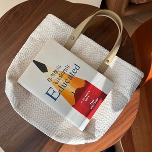 Retro beige woven canvas tote bag with grain pattern and leather handles on wooden table