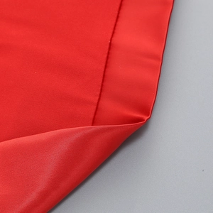 Detail of red elegant party dress showing smooth silk-like texture and fine stitching