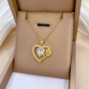 Detailed shot of golden heart pendant with crystal zircon and rose in a gift box