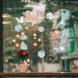 Close-up of hexagonal rainbow window stickers showing prismatic light on glass