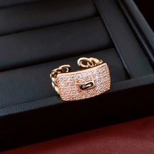 Macro shot of gold rectangle pavé zircon ring with chain design on black leather cushion