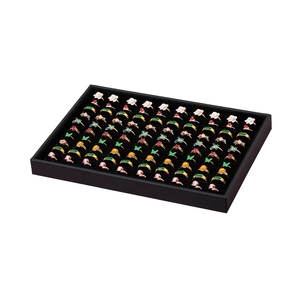 Black velvet jewelry tray displaying various colorful gemstone rings in rows
