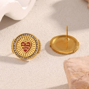 Detail of 18K gold-plated studs with red hearts and All YOU NEED IS LOVE text