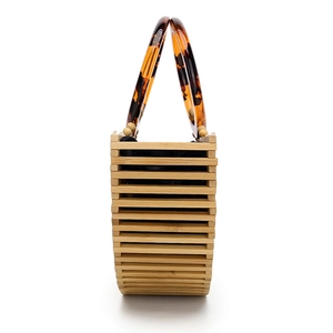 Detail of bamboo slats handbag featuring acrylic tortoiseshell handles and inner fabric liner