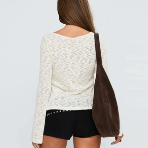 Vue arrière d'un crop top blanc en maille à manches longues avec un sac en daim brun
