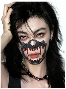 Detail of a black Halloween half-face demon mask with blood-stained fangs for cosplay