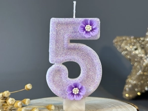 Detail of purple glitter number 5 birthday candle with two delicate 3D floral accents