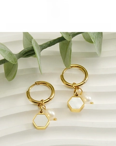 Close-up of 18K gold plated hexagonal earrings with pearls on white gypsum tray