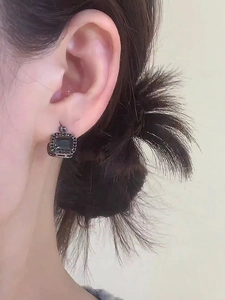 Close-up detail of elegant square huggie earrings with a black crystal and pave stones