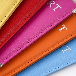 Macro view of colorful pebbled PU leather passport covers with silver lettering and stitching