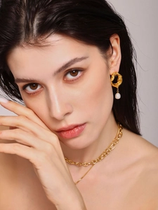 Détail de boucles d'oreilles lave en or 18k avec perle d'eau douce sur mannequin