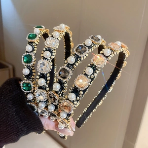 Detailed view of handmade baroque headbands with emerald crystals and faux pearls