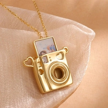 Macro detail of golden camera locket pendant showing the slot for custom photo insertion