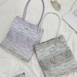 Detail of purple and grey lace tote bags featuring intricate sequins and floral embroidery